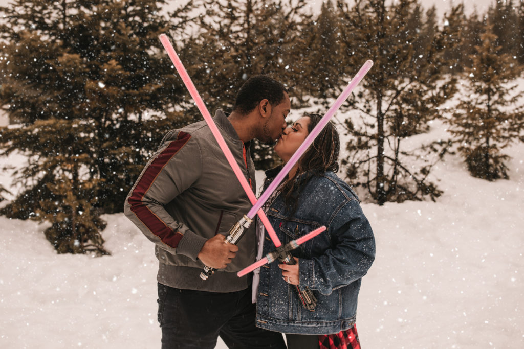 Couple kissing with lightsabers